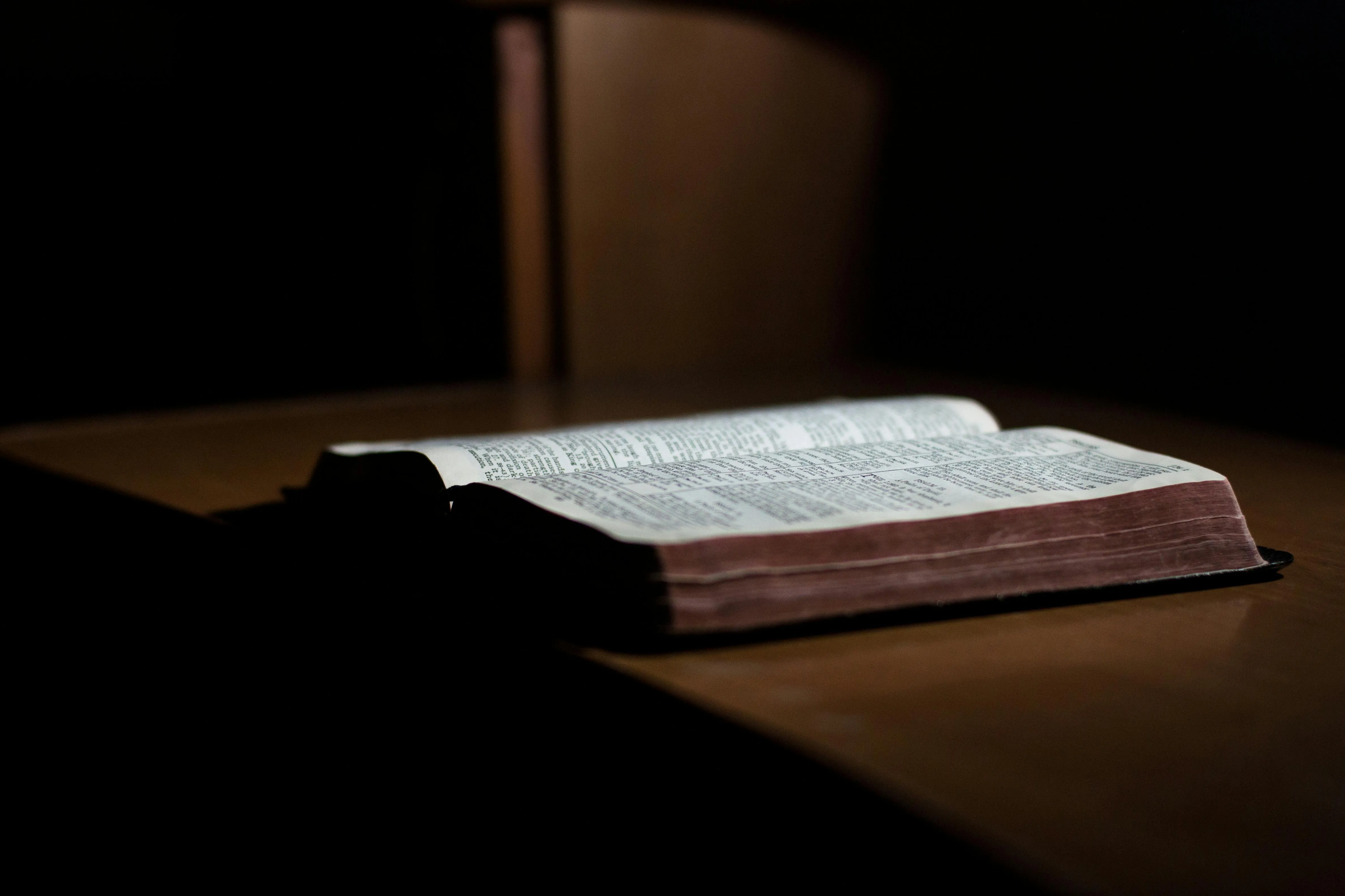 Open Bible on a wooden table.
